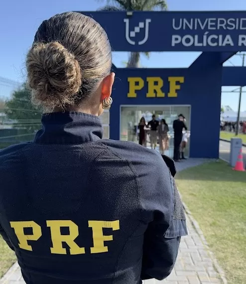 Adriana fardada da PRF na frente da Universidade da Polícia Rodoviária Federal